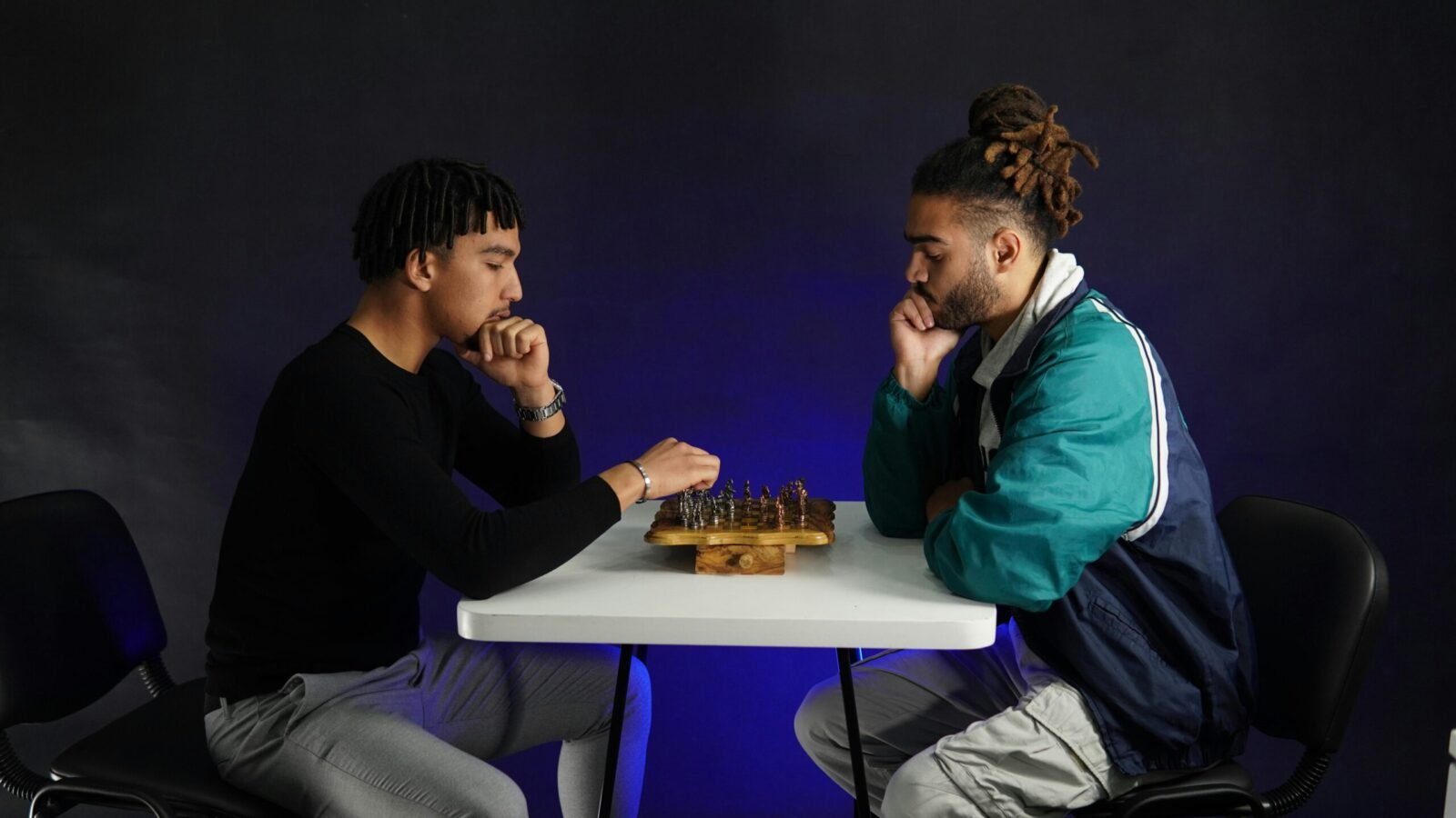 Two adults deeply engaged in a strategic chess match indoors, fostering concentration.