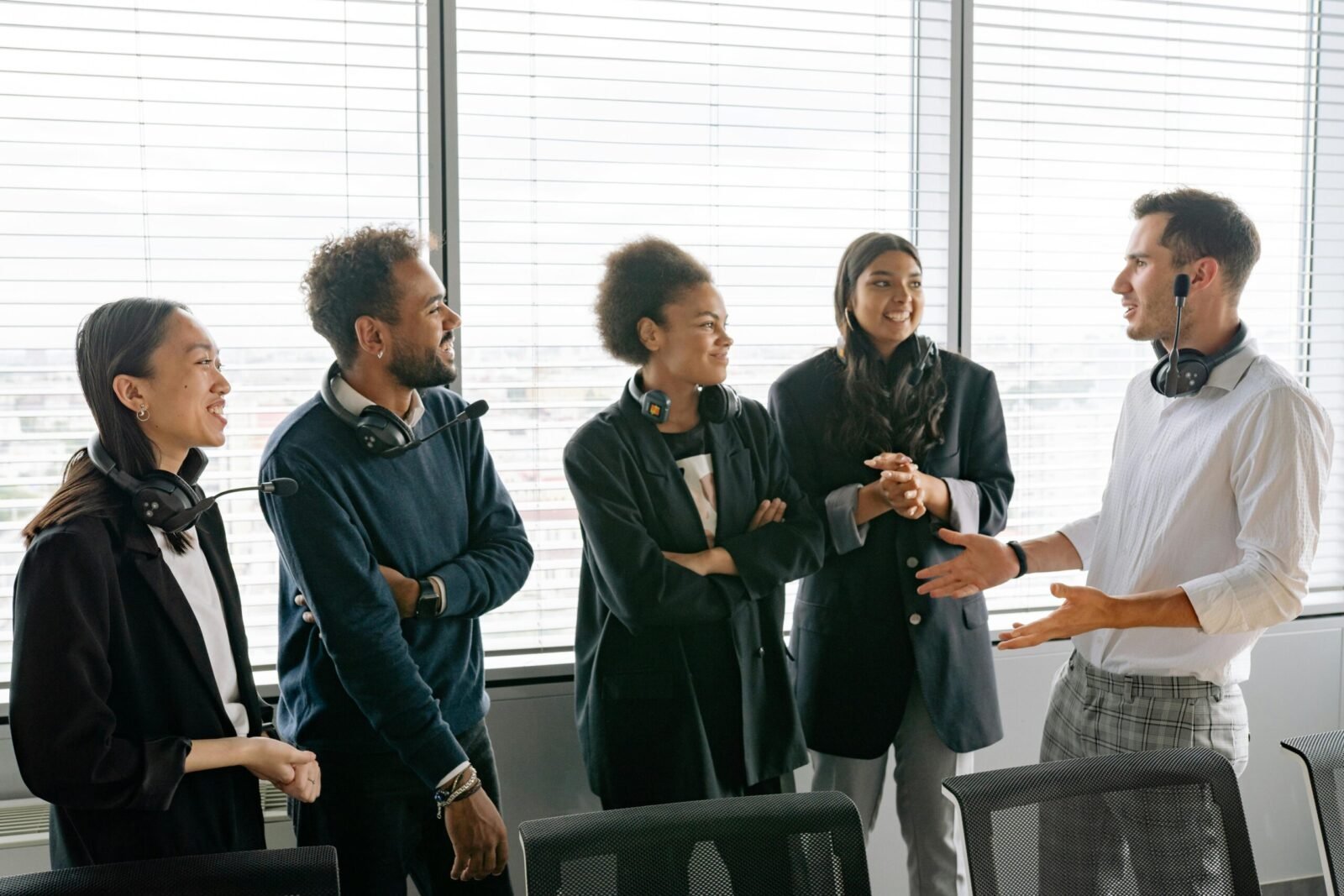 A diverse group of professionals having a conversation in a modern office environment.